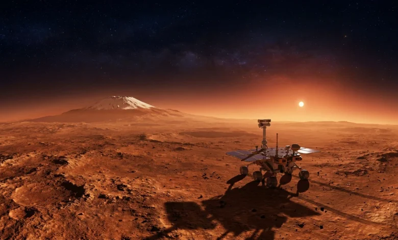 Un rover robotique sur la surface rouge de Mars au crépuscule, avec un soleil lumineux, une montagne enneigée et un ciel étoilé.